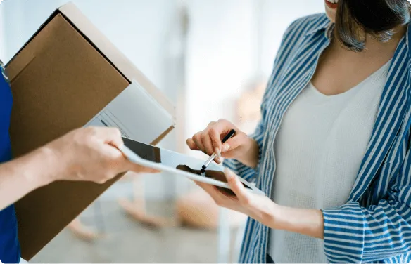 Kobieta podpisuje odbiór przesyłki / Female signing delivery of package