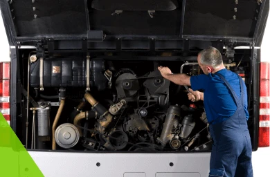 Mechanik naprawiający silnik pojazdu Mechanik w niebieskiej koszulce naprawia silnik w bagażniku pojazdu.