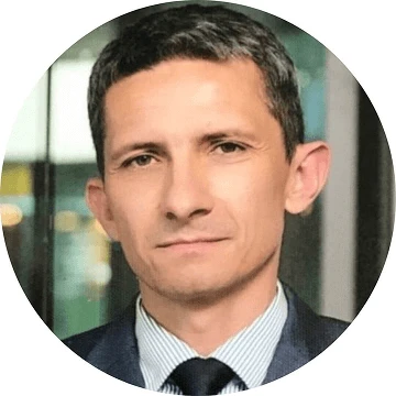 Close-up portrait of a businessman in a suit, looking confidently at the camera.