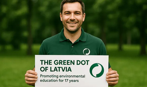 Vīrietis tur plakātu par Zaļo punktu Latvijā, veicinot vides izglītību.