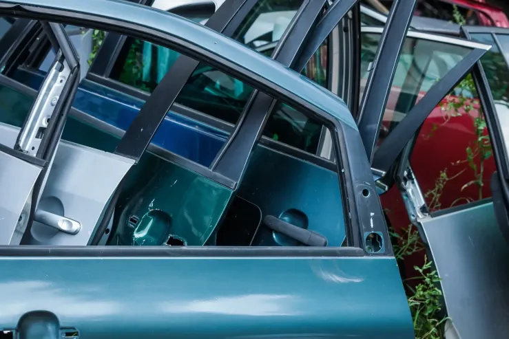 Automobilių durys metalo laužyne Metalo laužynas su įvairių spalvų automobilių durimis.