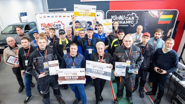 Grupė jaunųjų automobilių mechanikų su apdovanojimais ir diplomais.