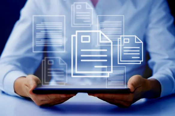 Osoba trzymająca tablet z hologramem dokumentów w tle.