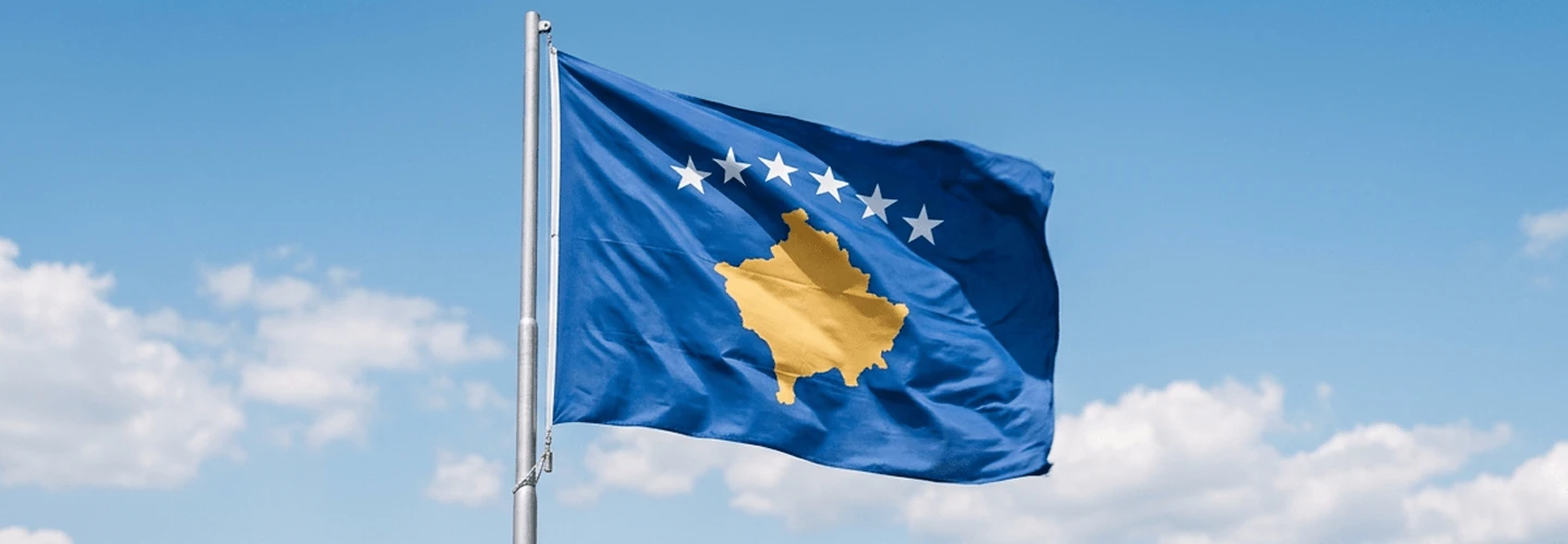 Flamuri i Kosovës kundër qiellit blu Flamuri i Kosovës me një hartë të verdhë dhe yje të bardhë, që valëviten në fllad nën një qiell blu.