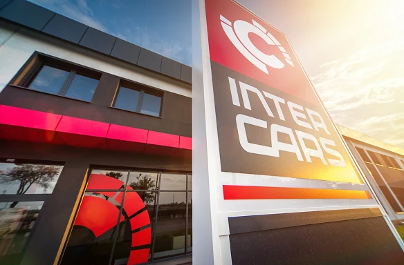 Widok zewnętrzny budynku Inter Cars z wyraźnym szyldem i nowoczesną architekturą.