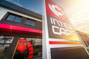 Widok zewnętrzny budynku Inter Cars z wyraźnym szyldem i nowoczesną architekturą.