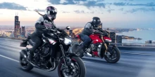 Motocykliści na miejskiej autostradzie o zmierzchu Dwóch motocyklistów w sprzęcie wyścigowym pędzi autostradą z panoramą miasta o zmierzchu.
