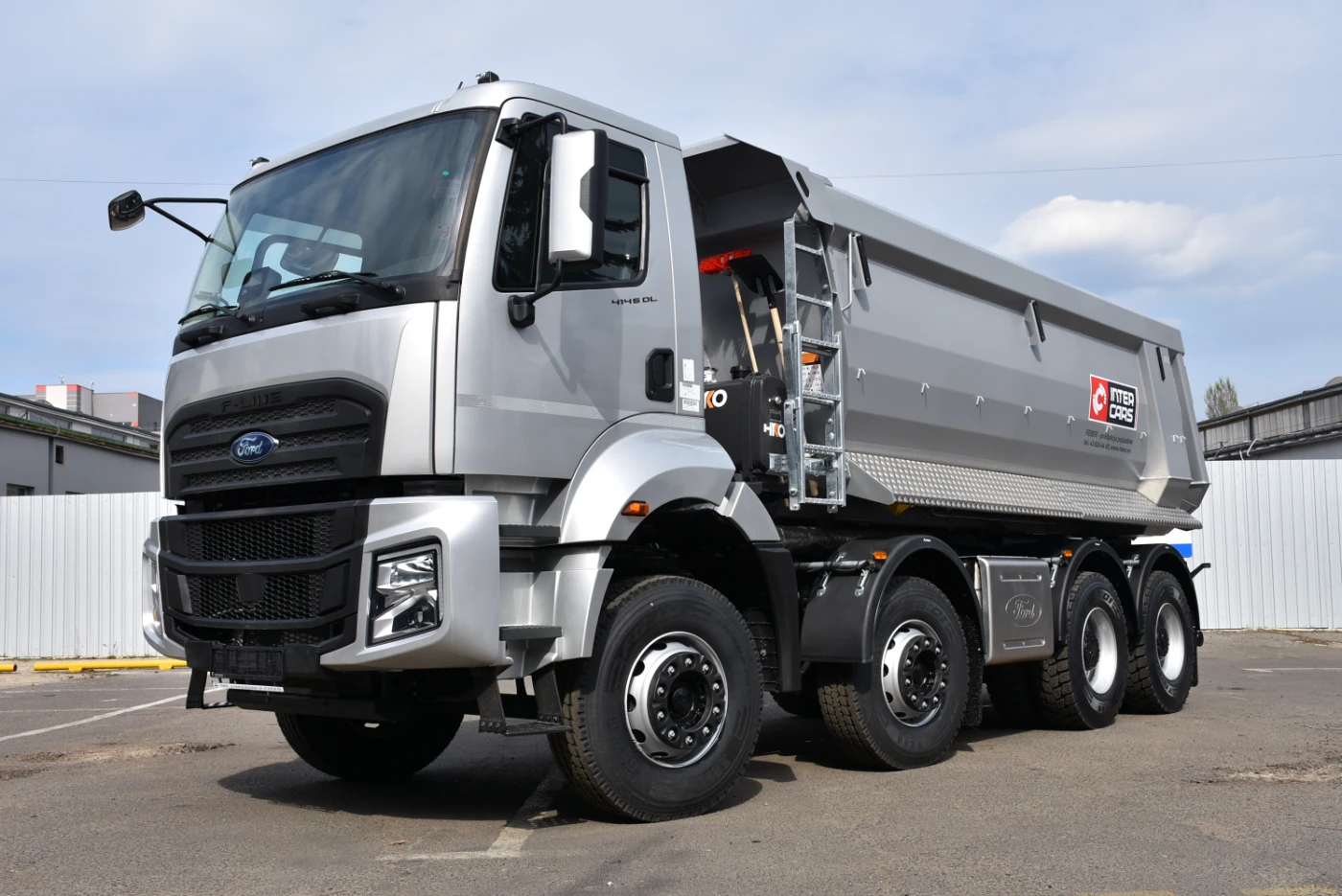Zaparkowana srebrna wywrotka Ford F-Line, prezentująca duży ładunek i nowoczesny design.